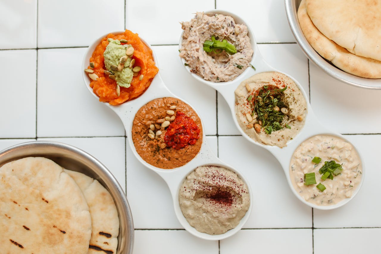 Middle Eastern mezze platter with assorted dips and pita bread.
